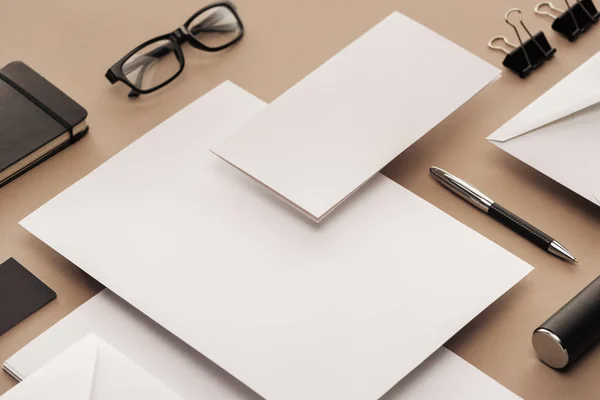 Colocación plana con gafas, bolígrafo, cuaderno, estuche, clips, sobres y hojas de papel — Stock Photo