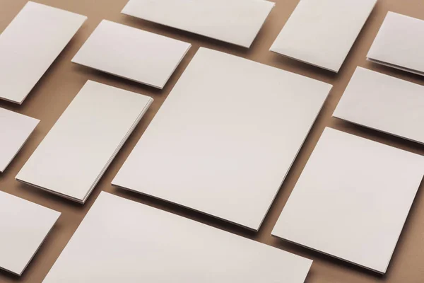 Tarjetas blancas y hojas de papel sobre fondo beige - foto de stock