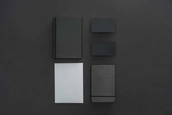 Feuille de papier, carnets et cartes sur fond noir — Photo de stock