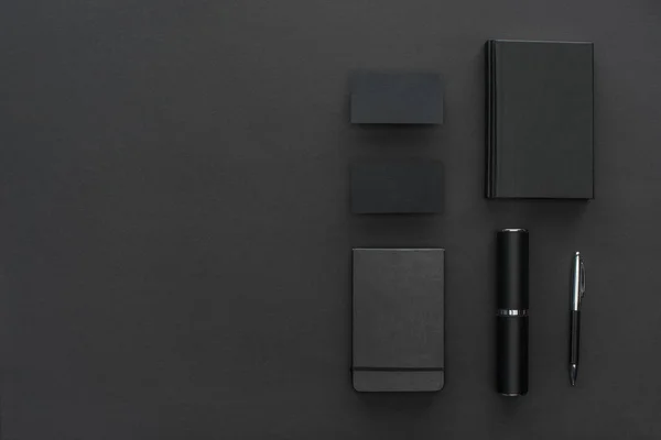 Cadernos, estojo, cartões e caneta sobre fundo preto — Fotografia de Stock