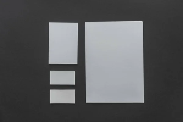 Vista superior de hojas de papel en blanco sobre fondo negro - foto de stock