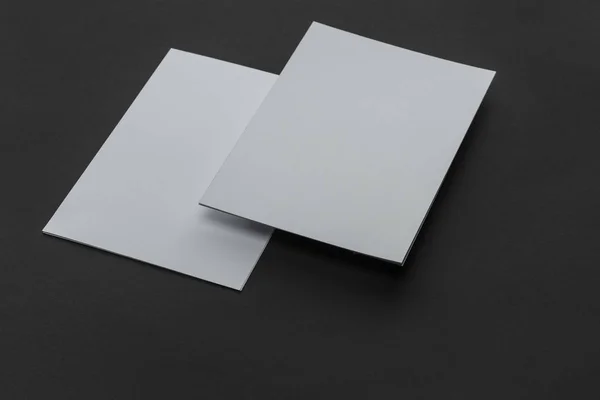 Hojas vacías de papel con espacio de copia sobre fondo negro - foto de stock