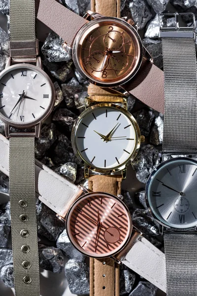 Top view of elegant wristwatches lying on grey stones — Stock Photo