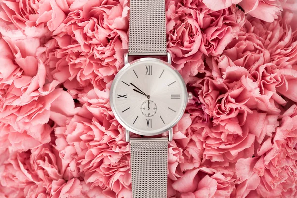 Vista superior del reloj de pulsera de lujo acostado en flores en flor - foto de stock
