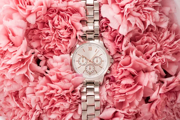 Top view of elegant wristwatch lying on blooming flowers — Stock Photo