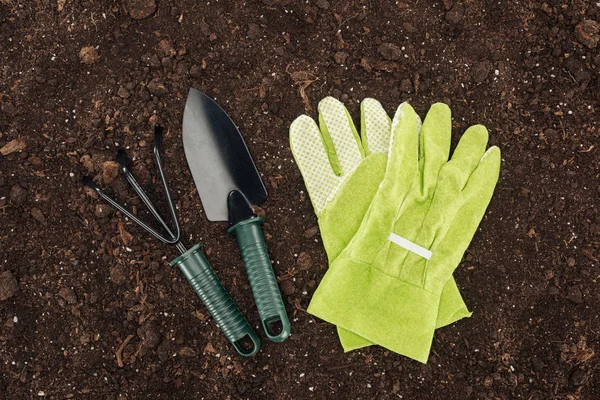 Верхний вид перчаток возле лопаты и грабли, защита концепции природы — стоковое фото
