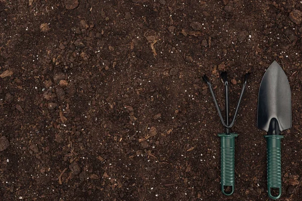 Top view of shovel and rake on ground, protecting nature concept — Stock Photo