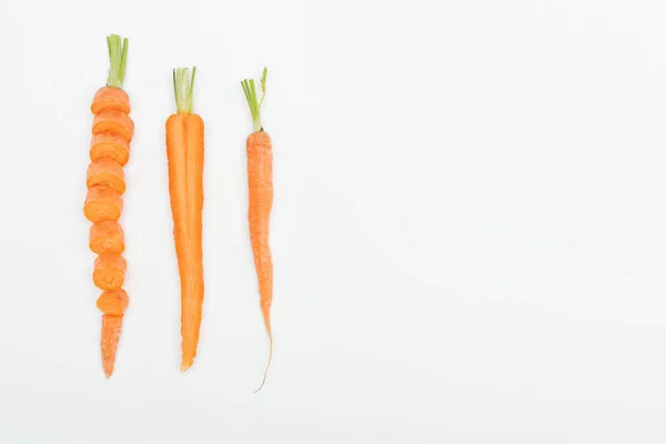 Aufgeschnittene Möhren, geschnittene Möhren und ganze Möhren isoliert auf weiß mit Kopierraum — Stockfoto