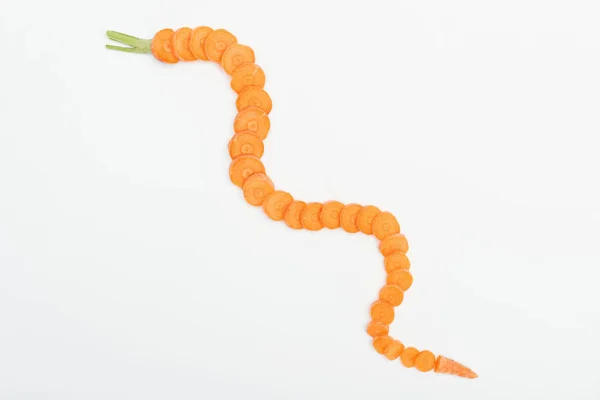 Верхний вид спелых сырых ломтиков моркови, выстроенных в изогнутую линию, изолированную на белом — стоковое фото