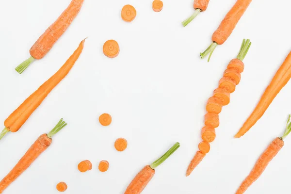 Vue de dessus des tranches de carotte, carottes entières et coupées isolées sur blanc — Photo de stock