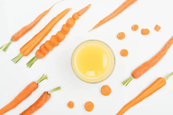 Top view of bowl of carrot fresh juice, carrot slices, whole and cut carrots isoltated on white — Stock Photo