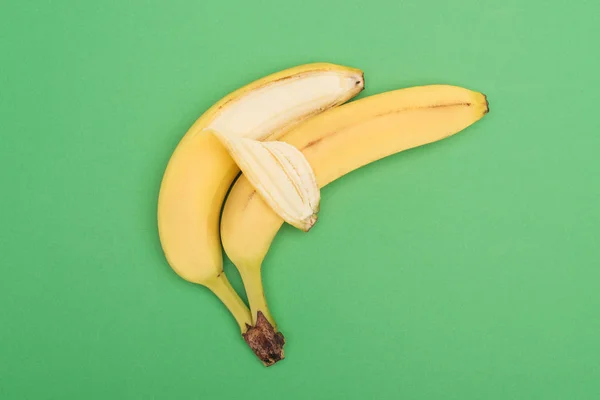 Draufsicht auf frische reife saftige Bananen auf grünem Hintergrund — Stockfoto