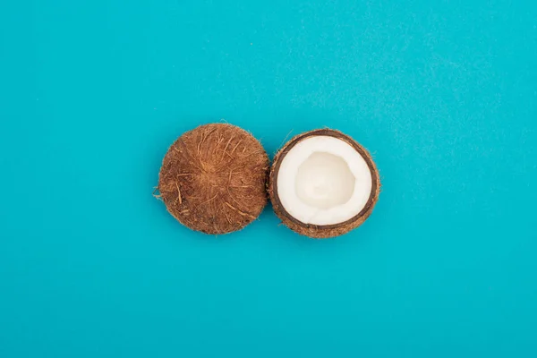 Верхний вид спелых кокосовых половинки на голубом фоне — стоковое фото