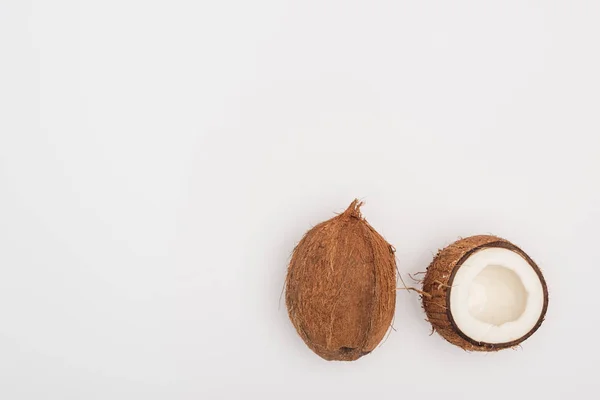 Top view of whole coconut and coconut half on grey background — Stock Photo