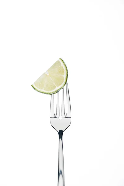 Half slice of fresh ripe juicy lime on fork isolated on white — Stock Photo