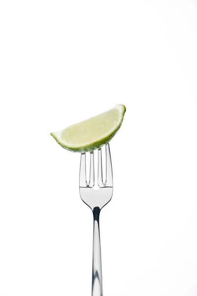 Slice of fresh ripe juicy lime on fork isolated on white — Stock Photo