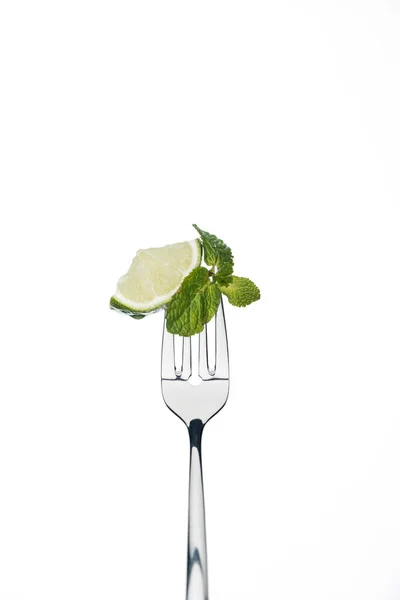 Slice of lime and mint leaves on fork isolated on white — Stock Photo