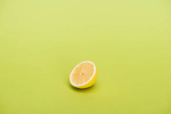 Die Hälfte frische saftige Zitrone auf grünem Hintergrund — Stockfoto