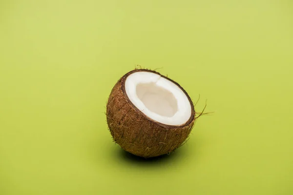 Half of ripe fresh coconut on green background — Stock Photo