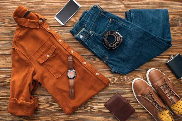 Flat lay with clothes, smartphone and wallet on wooden background — Stock Photo