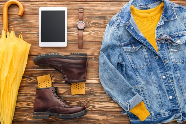 Pose plate avec tablette numérique, chaussures et veste en denim sur fond en bois — Photo de stock