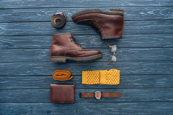 Flat lay com botas marrons, carteira e óculos em fundo de madeira — Fotografia de Stock