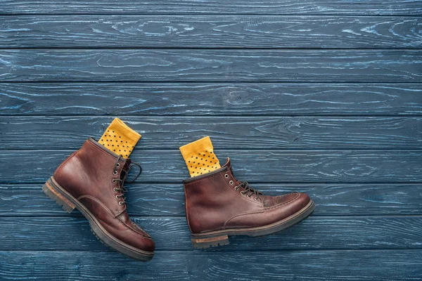 Top view of brown shoes and yellow socks on wooden background — Stock Photo