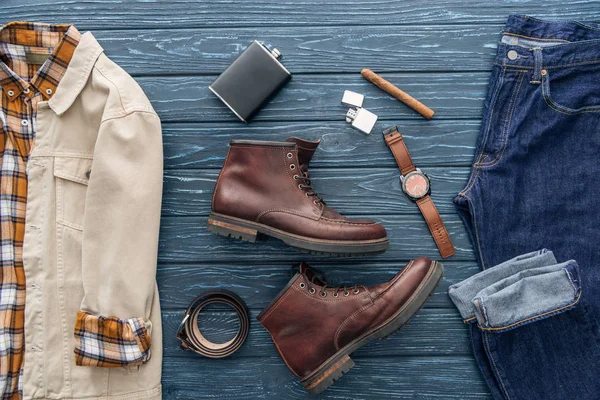 Vista superior de ropa masculina, zapatos y cigarros sobre fondo de madera - foto de stock
