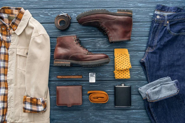 Acostado plano con ropa masculina, zapatos, cigarros y accesorios sobre fondo de madera - foto de stock