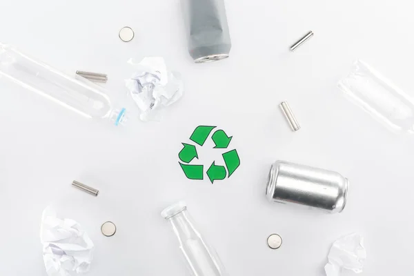 Cans, plastic and glass bottles, batteries, paper and recycling sign — Stock Photo