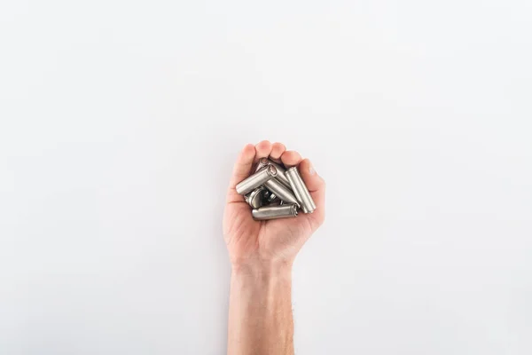 Partial view of man holding batteries on grey background — Stock Photo