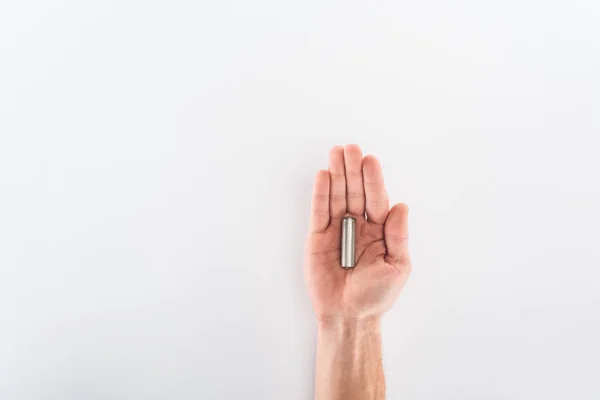 Vista parcial del hombre sosteniendo la batería sobre fondo gris - foto de stock