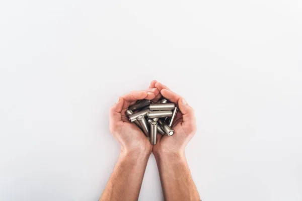 Cropped view of man holding batteries on grey background — Stock Photo