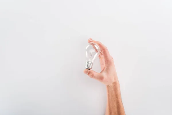 Cropped view of man holding bulb on grey background — Stock Photo