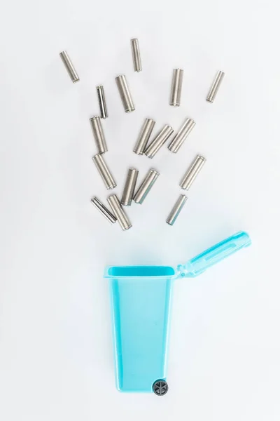 Vue du dessus de la poubelle jouet bleu et des piles sur fond gris — Photo de stock