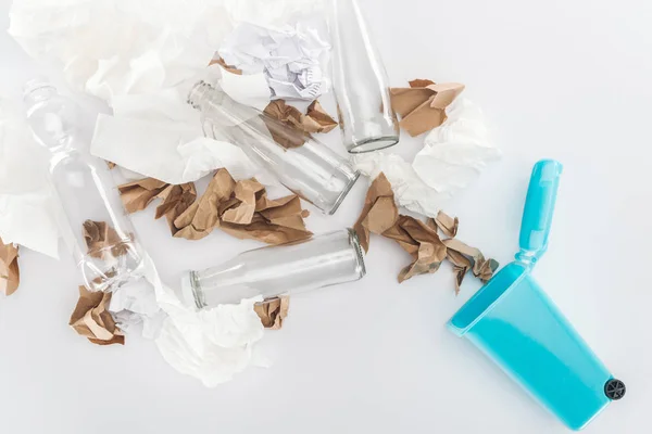 Top view of blue toy trashcan, glass and plastic bottles, paper on grey background — Stock Photo