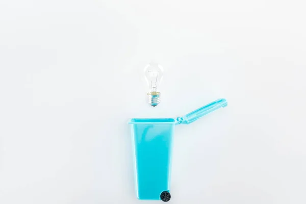 Top view of blue toy trashcan and bulb on grey background — Stock Photo