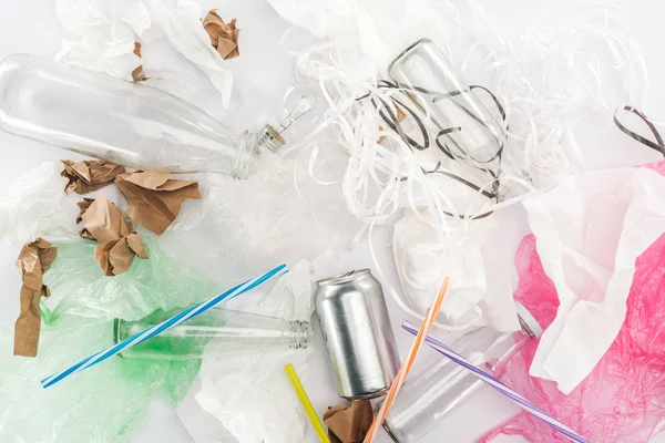 Vista dall'alto di lattine, bottiglie di vetro, strisce di carta, carta, lampadine, tubi di plastica e sacchetti di plastica — Foto stock