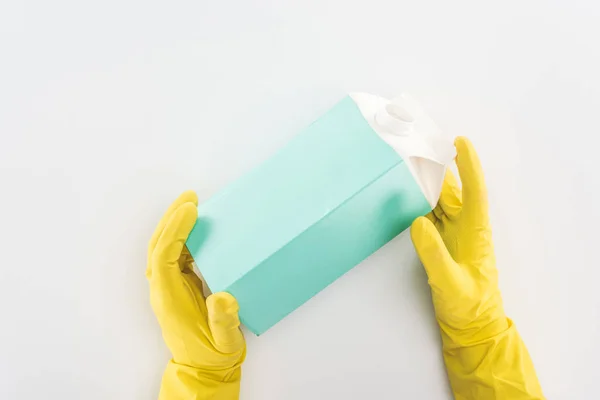 Cropped view of man in yellow rubber gloves holding empty carton bottle — Stock Photo