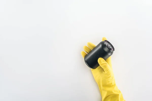 Обрезанный вид человека в жёлтых резиновых перчатках с пустой чёрной банкой на сером фоне — стоковое фото