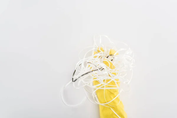 Vista cortada do homem em luvas de borracha amarela segurando tiras de papel no fundo cinza — Fotografia de Stock