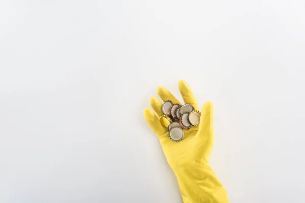 Vista cortada do homem em luvas de borracha amarela segurando tampas de garrafa — Fotografia de Stock