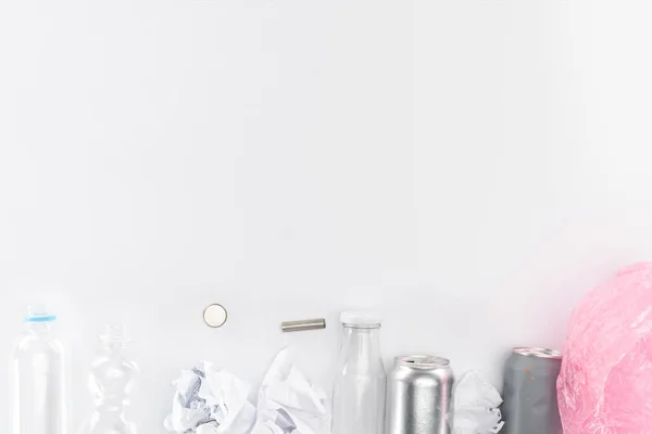 Vue du dessus des canettes, bouteilles en plastique et en verre, piles, papier et sac en plastique rose — Photo de stock