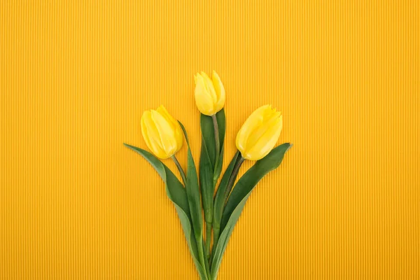 Vista superior del ramo con tulipanes amarillos sobre fondo naranja para el día internacional de la mujer — Stock Photo