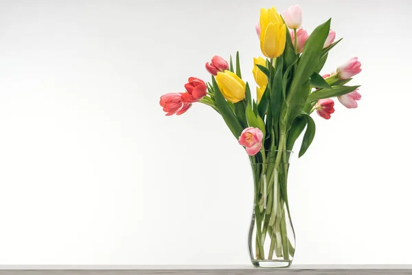 Ramo de tulipanes coloridos en jarrón para el día internacional de la mujer, en blanco — Stock Photo