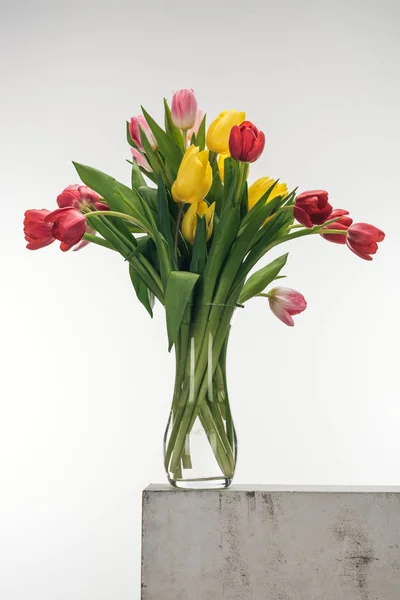 Bouquet di tulipani in vaso di vetro su bianco — Foto stock