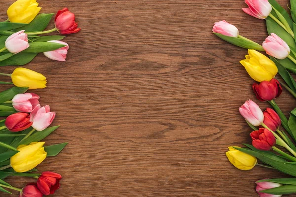 Top view of colorful tulips on wooden background with copy space — Stock Photo