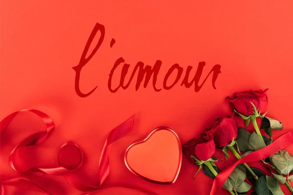 Vista superior de la caja en forma de corazón y rosas aisladas en rojo con letras 