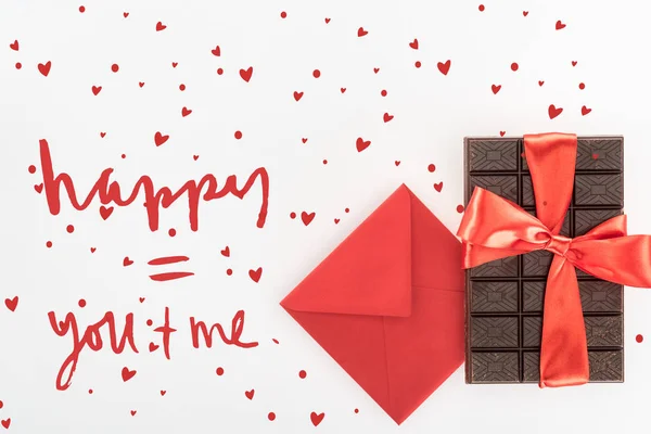 Vue d'en haut de l'enveloppe et délicieux chocolat enveloppé par un ruban festif isolé sur blanc, concept St Valentin avec lettrage amour — Photo de stock