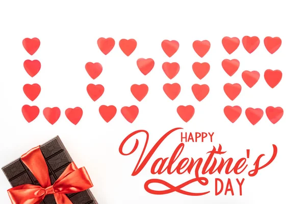 Acostado plano con letras de amor hechas de símbolos del corazón y chocolate envuelto por cinta festiva aislado en blanco, feliz día de San Valentín con letras de 